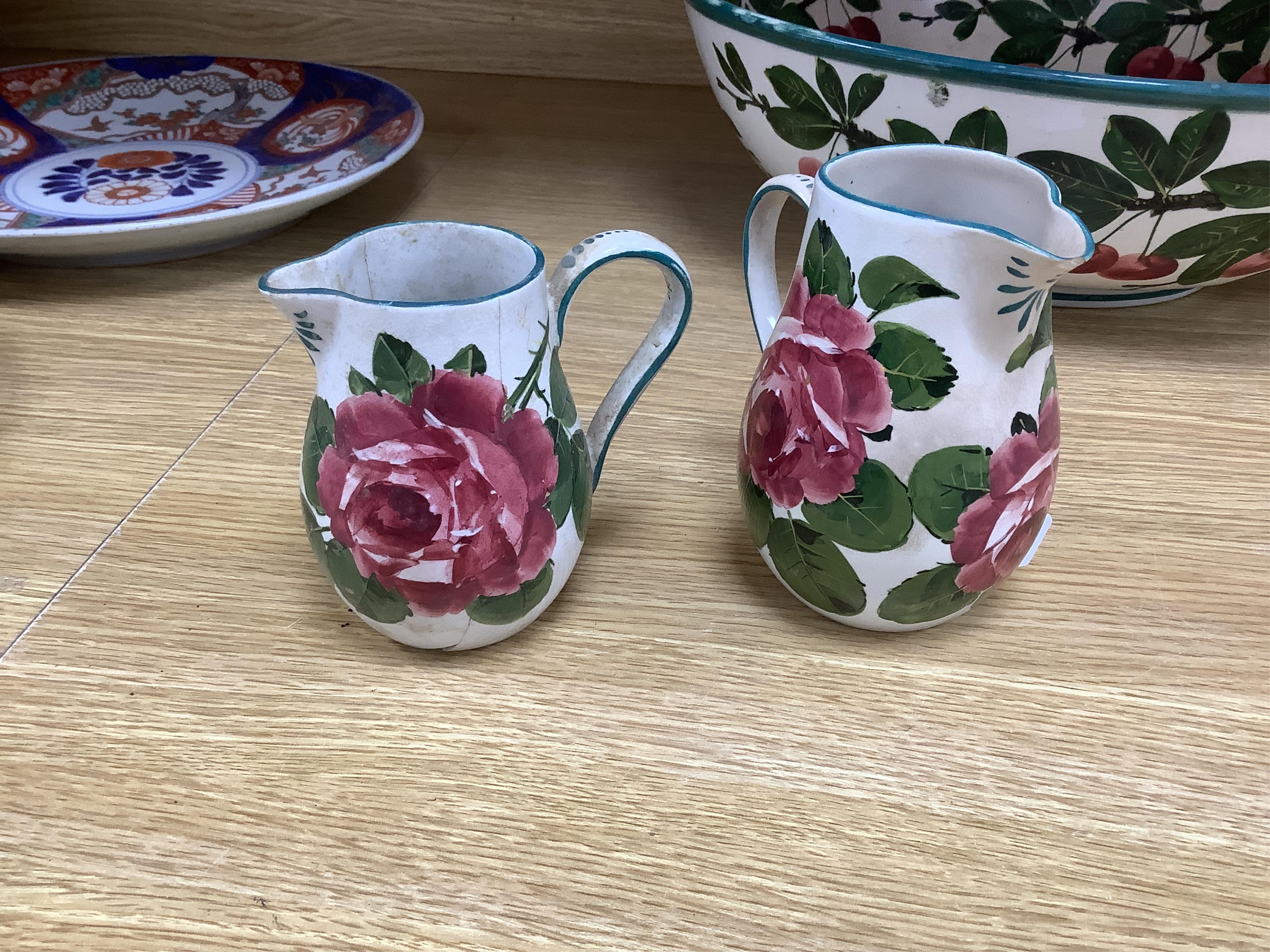 A Wemyss cherry branch decorated basin and two Wemyss jugs painted with cabbage roses, basin 38.5cm diameter. Condition- poor